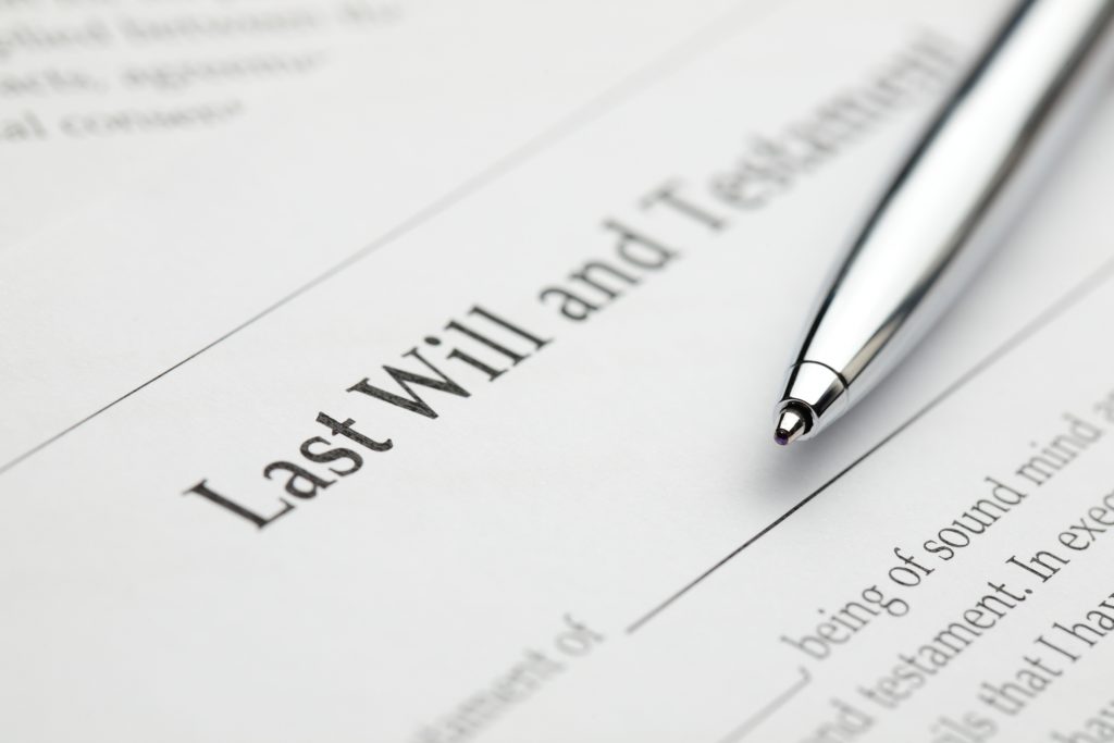 A blank last will and testament form with a pen laying over it.